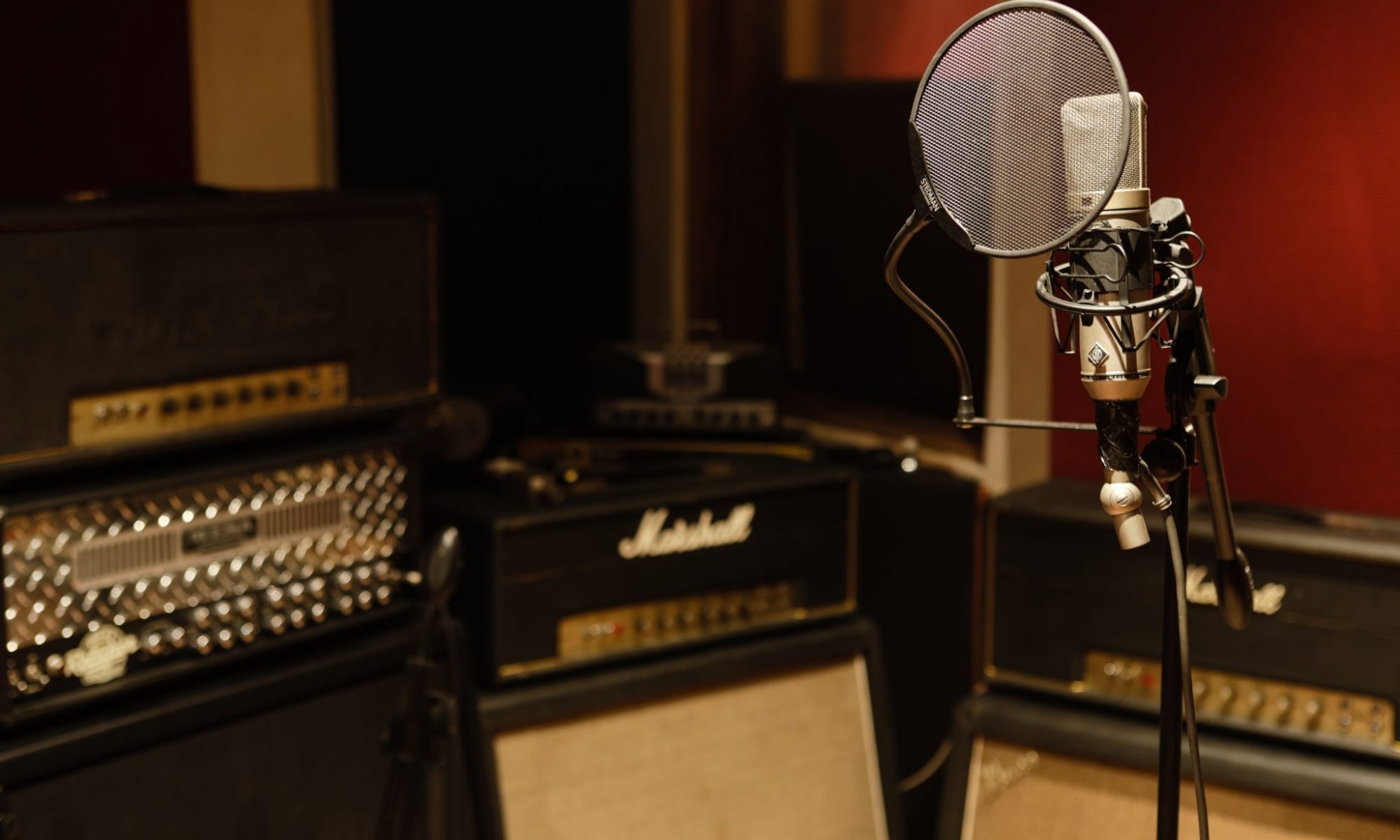 Photo taken by Andy Lund of Neumann U87 microphone with guitar amplifiers in background
